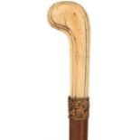 A LATE 19TH/EARLY 20TH CENTURY WALKING CANE, the ivory handle simply carved, yellow metal pierced