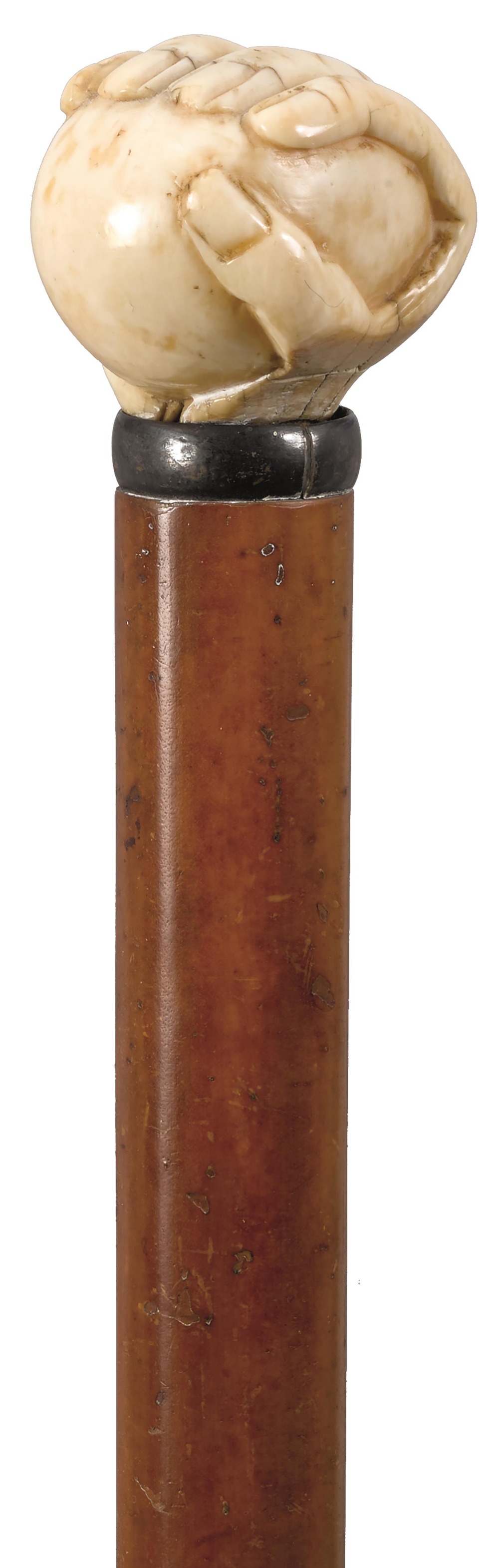 AN EARLY 20TH CENTURY WALKING CANE, the ivory handle carved as a fist holding a ball, malacca