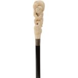 A LATE 19TH CENTURY WALKING CANE, the Japanese ivory handle carved as a man carrying a large