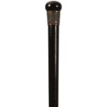 AN EARLY 20TH CENTURY EBONISED WALKING CANE, the bun handle above white metal foliate embossed