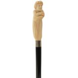 A LATE 19TH/EARLY 20TH CENTURY WALKING CANE, the earlier ivory pistol grip handle carved as a