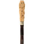 A LATE 19TH/EARLY 20TH CENTURY WALKING CANE, the ivory handle carved as an owl with glass eyes and a