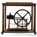 A PAINTED LIVE STEAM MODEL OF A HORIZONTAL MILL ENGINE, mounted on a wooden plinth and contained