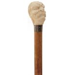 A 19TH CENTURY WALKING CANE, the substantial ivory handle carved as the head of the Zaporozhian