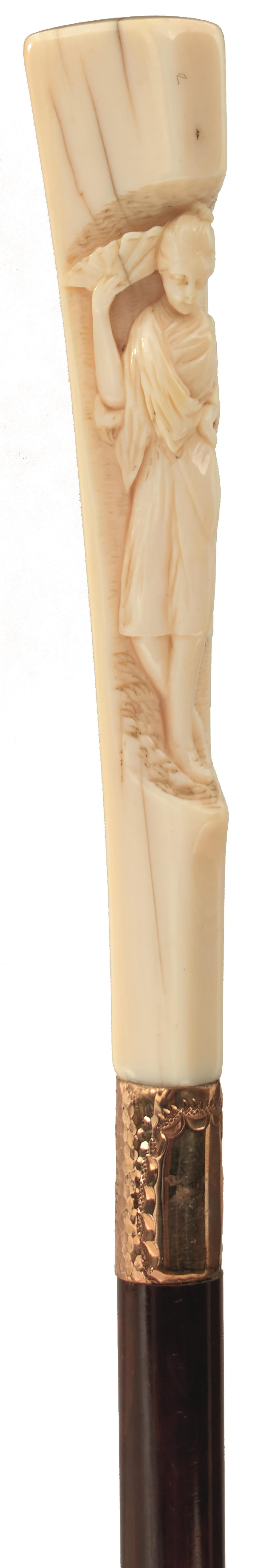 AN EARLY 20TH CENTURY WALKING CANE, the ivory handle carved in semi relief with a maiden carrying