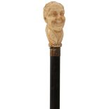 A LATE 19TH/EARLY 20TH CENTURY WALKING CANE, the ivory handle carved as the head of a Dickensian