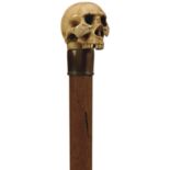 A LATE 19TH CENTURY WALKING CANE, the ivory handle carved as a skull, malacca haft, metal ferrule,