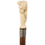 AN EARLY 20TH CENTURY WALKING CANE, the ivory handle carved as a toad clambering up a pole, above