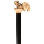 AN UNUSUAL WALKING CANE, the ivory handle carved as a seated tiger emerging from cornucopia, ebony