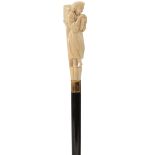 A LATE 19TH/EARLY 20TH CENTURY WALKING CANE, the ivory handle carved as a female figure holding a