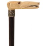 A LATE 19TH/EARLY 20TH CENTURY WALKING CANE, the ivory handle carved as a greyhound with glass