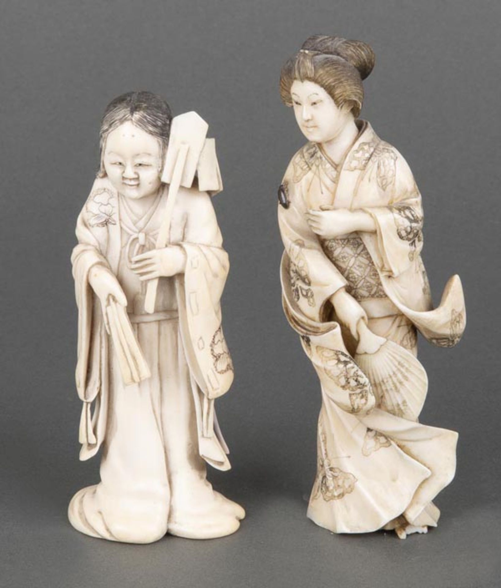Zwei Geishas. Japan. Elfenbein, geschnitzt und graviert, H=11,8 / 13,2 cm. (besch.)