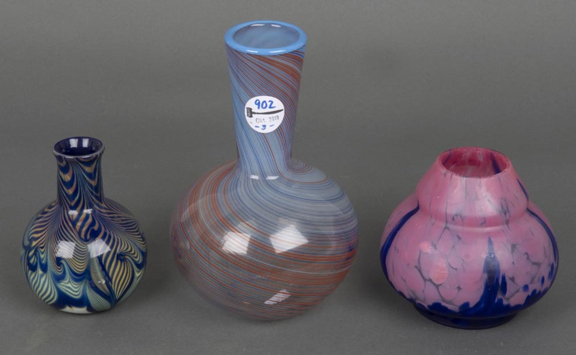 Drei Vasen, u.a. Murano 20. Jh. Farbloses Glas, farbig überfangen, H=12,5 bis 22,5 cm.- - -25.00 %
