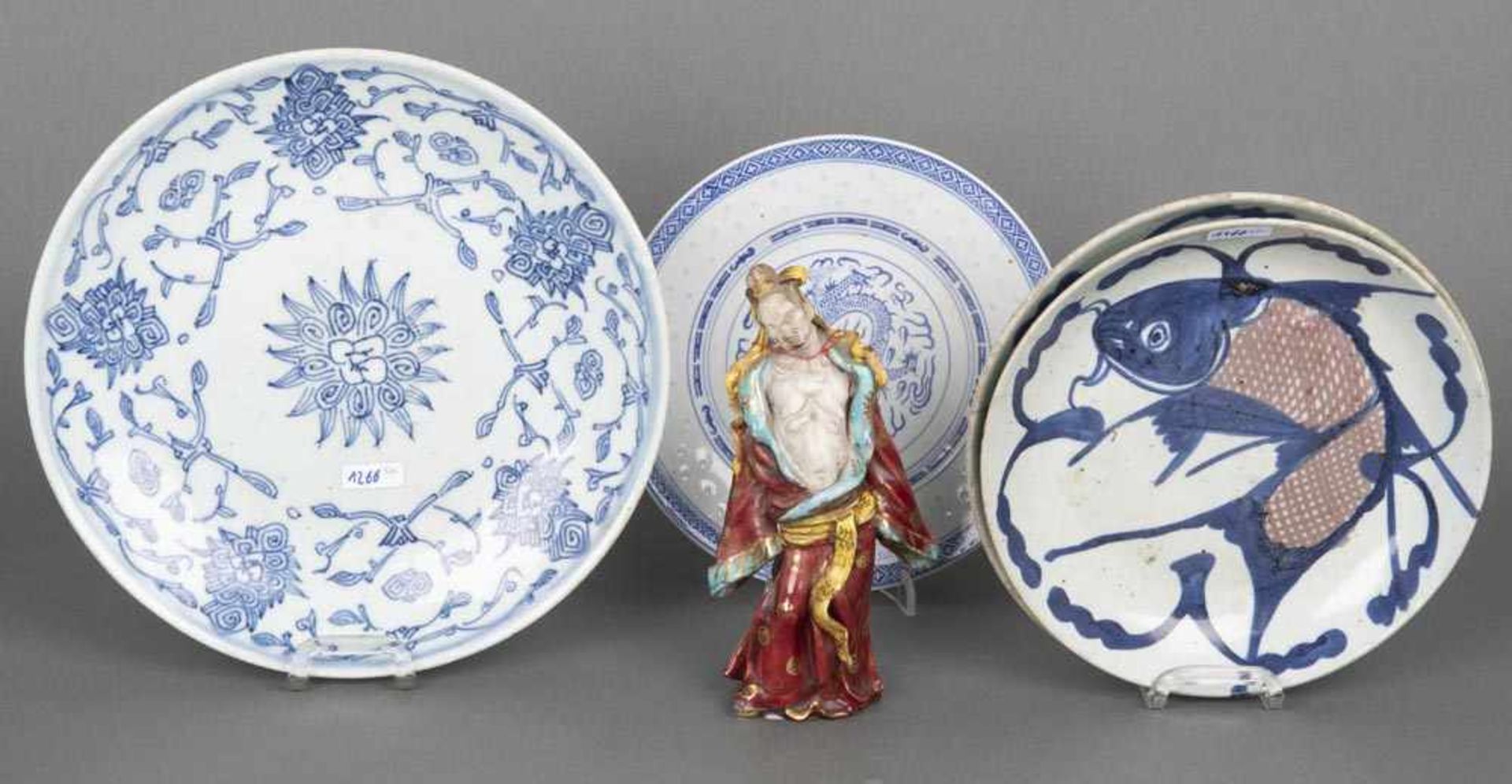 Drei Teller und eine Figur. China. Porzellan, meist unterglasurblau floral bemalt, H=18,5 cm, / D=20
