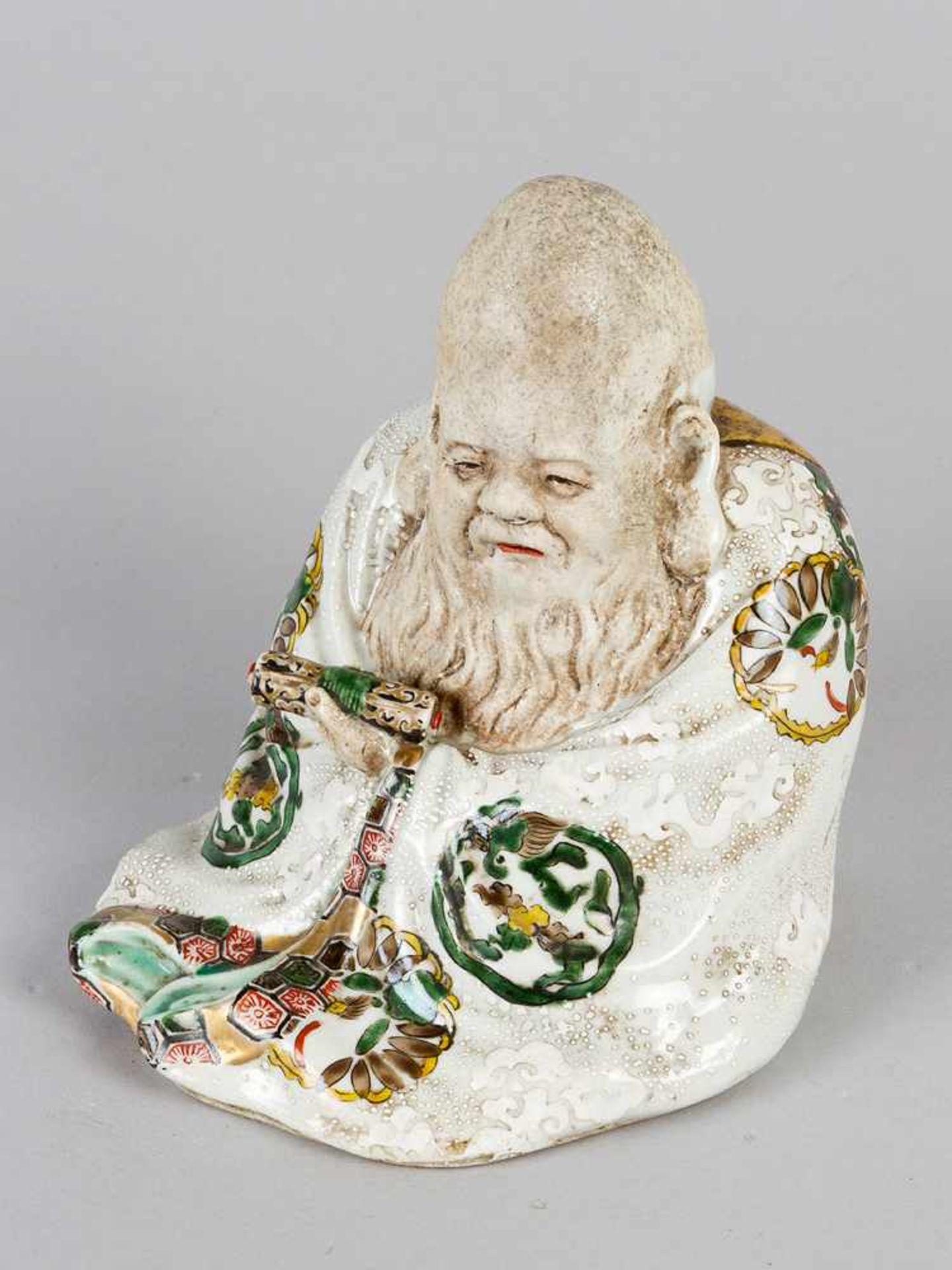 Chinese Porcelain figure of a wise men with script-role and coat, partly painted and glazed. 19th
