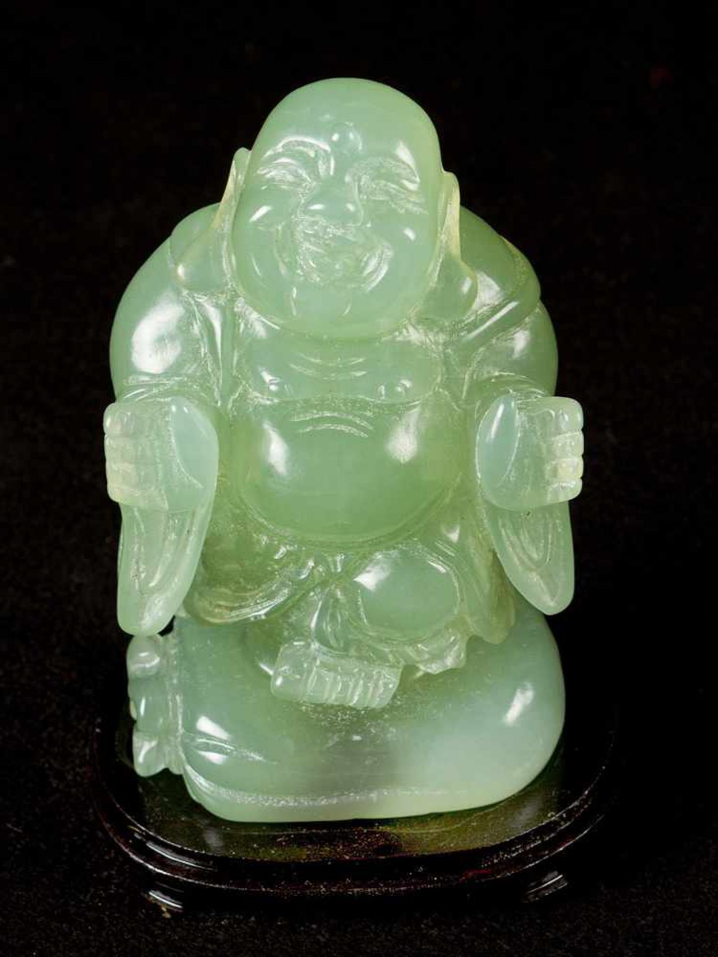 Standing Buddha, sculpted light green jade on ebonized base, Qing Dynasty.11,5 cm high- - -24.00 %