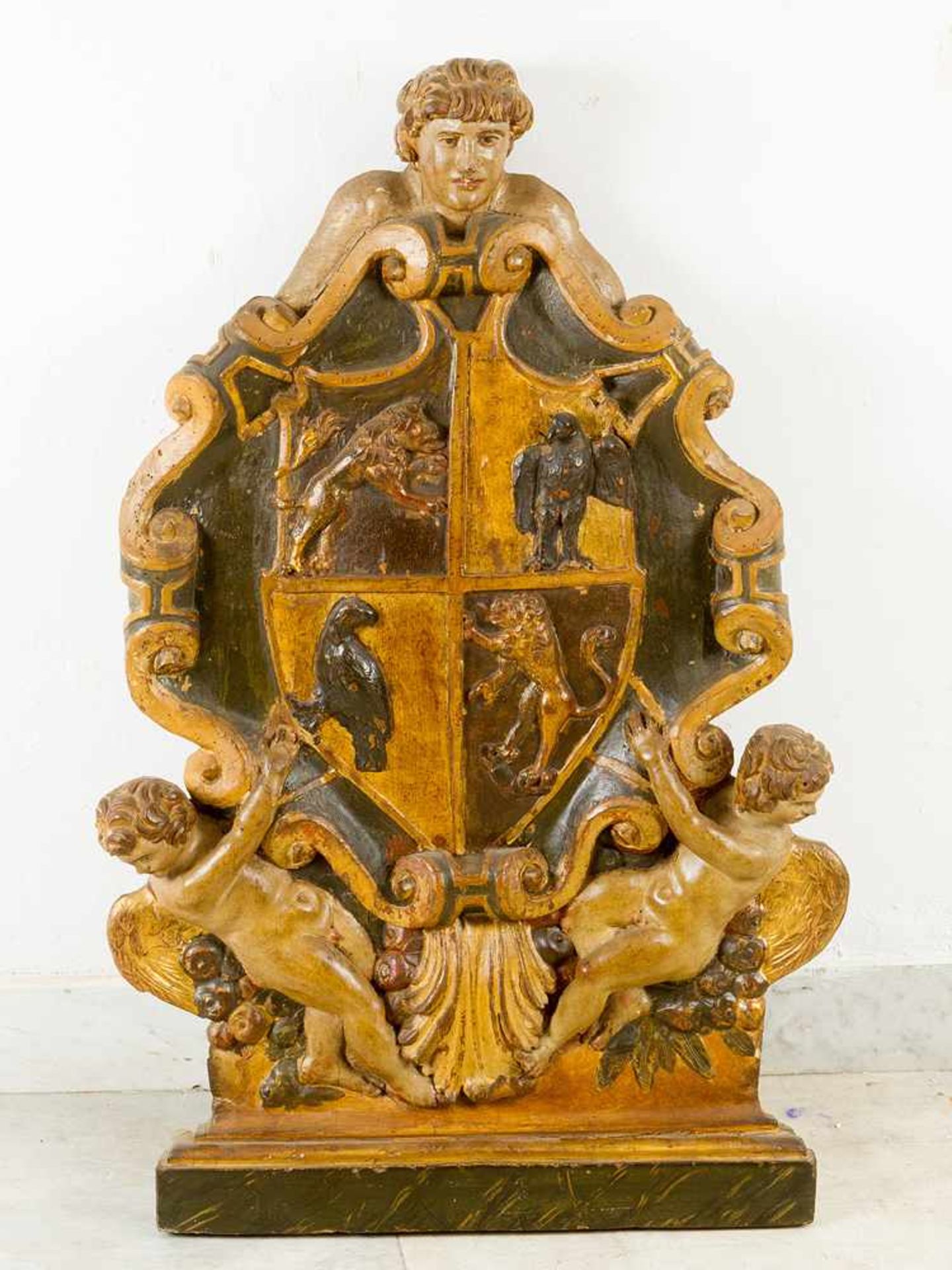 Italian family Coat of Arms, wood carved with two winged angels, fruits and boy’s head on top; in