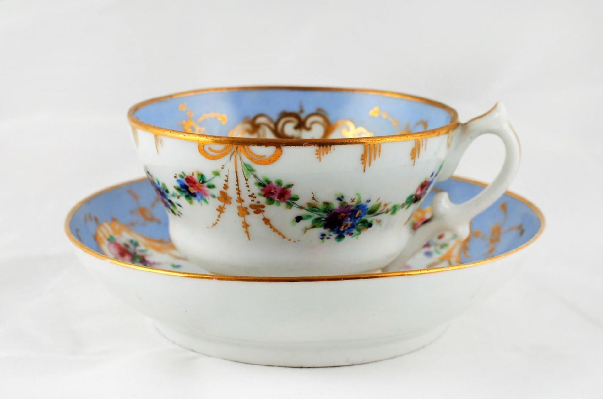 A teacup and a saucer with floral motifs. Porcelain Factory of the Kornilov Brothers. Saint