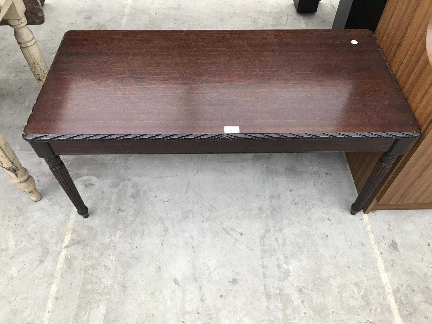 A MAHOGANY COFFEE TABLE ON TAPERED SUPPORTS