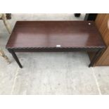 A MAHOGANY COFFEE TABLE ON TAPERED SUPPORTS