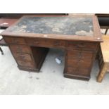 AN OAK TWIN PEDESTAL DESK WITH CENTRE DRAWER, TWO SETS OF FOUR SIDE DRAWERS AND LEATHER WRITING