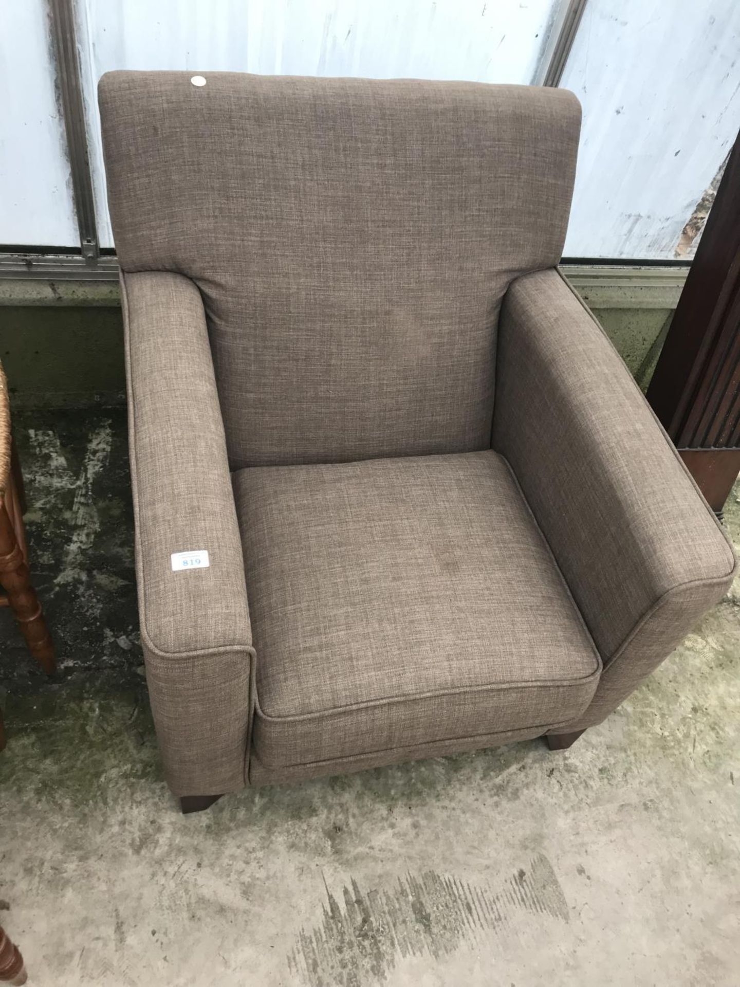 A BROWN FABRIC ARMCHAIR