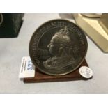 A COMMEMORATIVE 'QUEEN VICTORIA' COIN ON WOODEN BASE
