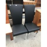 TWO BLACK HIGH BACKED DINING CHAIRS ON STAINLESS STEEL SUPPORTS