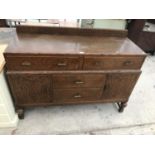 AN OAK SIDEBOARD WITH TWO DOORS AND FOUR DRAWERS