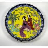 A 1970'S JAPANESE POTTERY PLATE WITH LADIES IN OUTDOOR SETTING, WIDTH 22CM