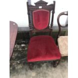 A HEAVILY CARVED MAHOGANY DINING CHAIR WITH RED FABRIC SEAT AND BACK