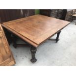 A LARGE OAK DRAW LEAF TABLE ON TURNED SUPPORTS