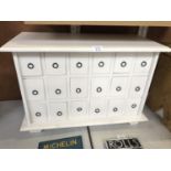 A WHITE PAINTED WOODEN EIGHTEEN DRAWER SPICE CABINET