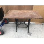 A WOODEN TOP TABLE ON A CAST IRON SEWING MACHINE FRAME 113CM X 60.5CM