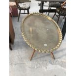 AN OVAL BRASS TOPPED COFFEE TABLE ON MAHOGANY SUPPORTS