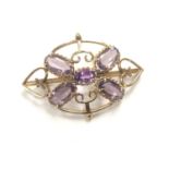 A LADIES 9CT YELLOW GOLD EDWARDIAN BROOCH WITH CENTRAL AMETHYST STONE AND FOUR FURTHER PINK STONES