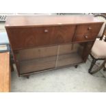 A RETRO TEAK CABINET WITH LOWER GLAZED SLIDING DOORS, UPPER DOOR AND TWO DRAWERS