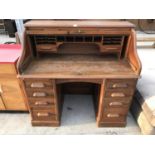 AN OAK ROLL TOP DESK WITH EIGHT DRAWERS