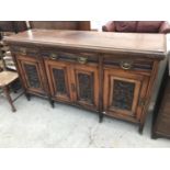 A MAHOGANY SIDEBOARD WITH FOUR CARVED DOORS AND THREE DRAWERS WITH BRASS HANDLES