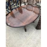 AN OVAL MAHOGANY COFFEE TABLE ON CENTRE PEDESTAL SUPPORT WITH LION'S PAW FEET