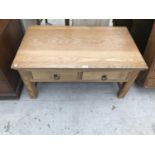 AN OAK COFFEE TABLE WITH TWO DRAWERS