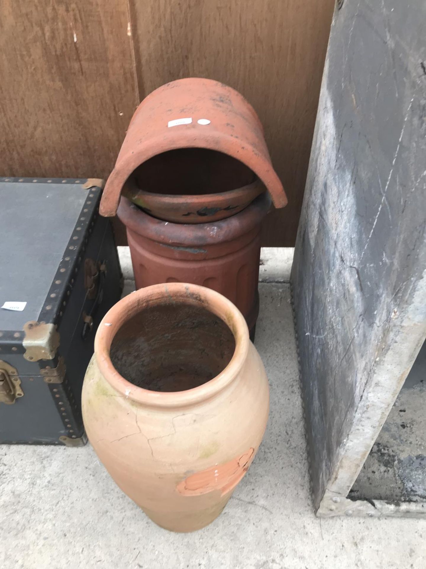 A CHIMNEY POT WITH COWL 64CM HIGH AND A TERRACOTTA URN 49CM HIGH