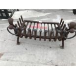 A VINTAGE CAST IRON DOG GRATE WITH BRASS FITTINGS