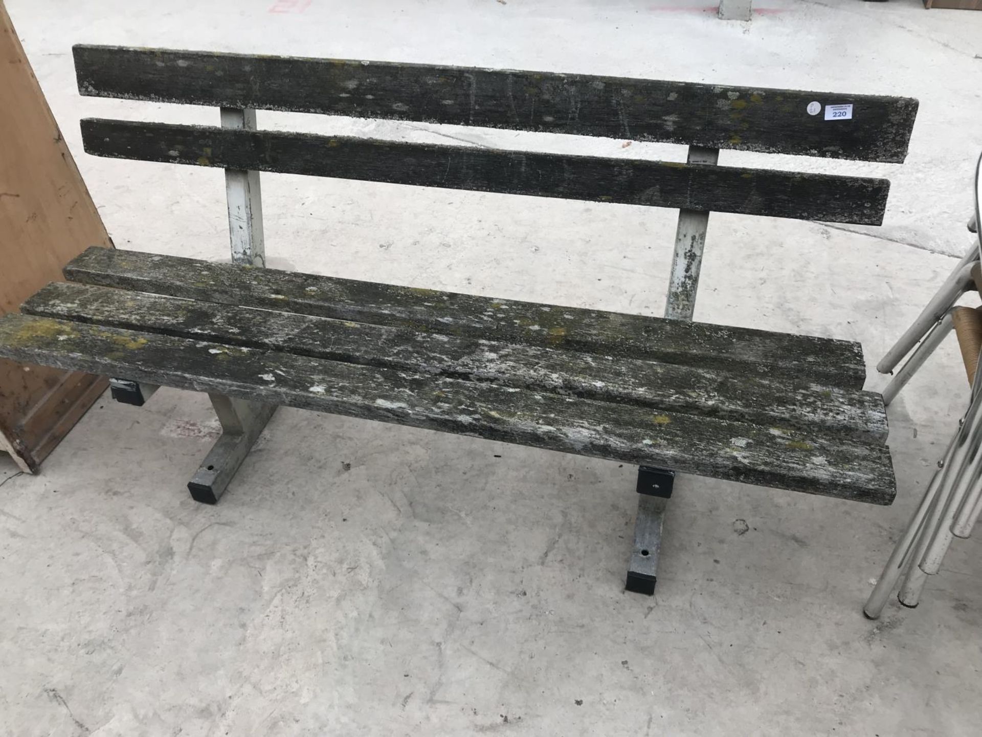 A WOODEN PARK BENCH ON METAL SUPPORTS