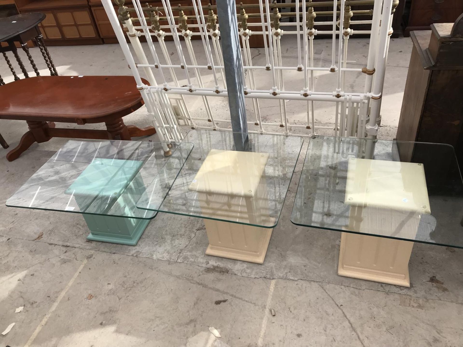 THREE GLASS TOPPED SIDE TABLES ON PAINTED COLUMN SUPPORTS
