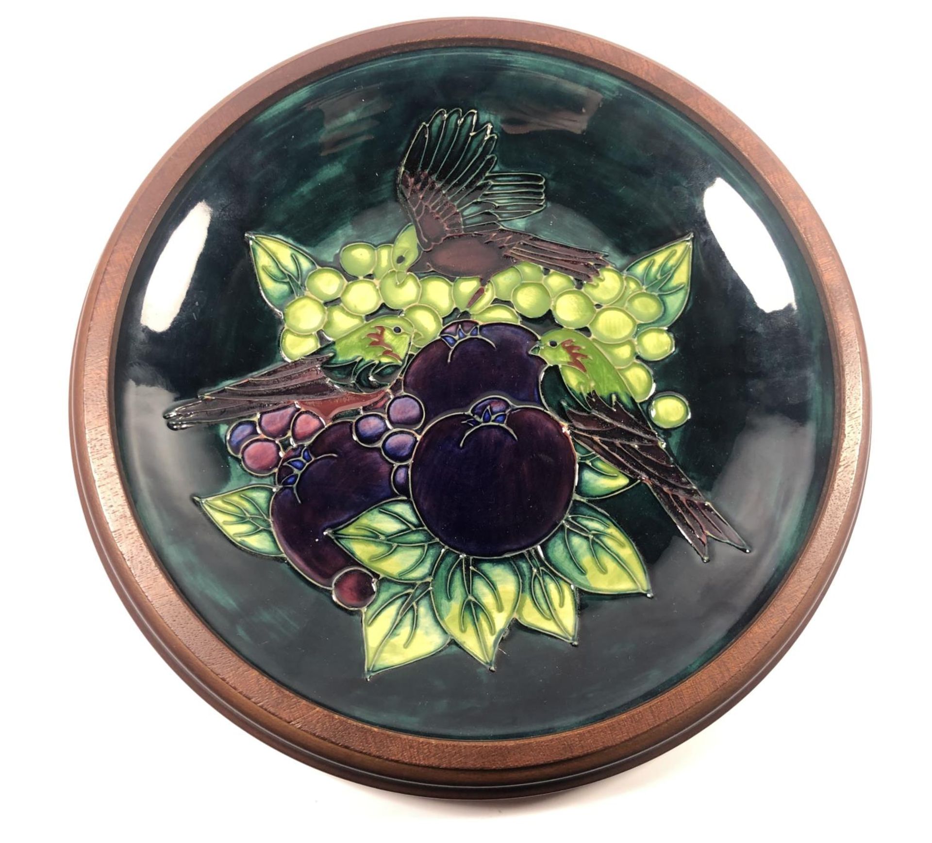 A MOORCROFT POTTERY 'FINCHES AND BERRY' PATTERN PLATE IN WOODEN SURROUND, DIAMETER 29CM (FIRSTS)