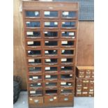 A VINTAGE SHOP CABINET WITH THIRTY THREE DRAWERS (91CM X 52.5CM X 198CM HIGH) PLAQUE - MADE BY