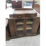 AN OAK CABINET WITH TWO GLAZED DOORS AND TWO UPPER DRAWERS