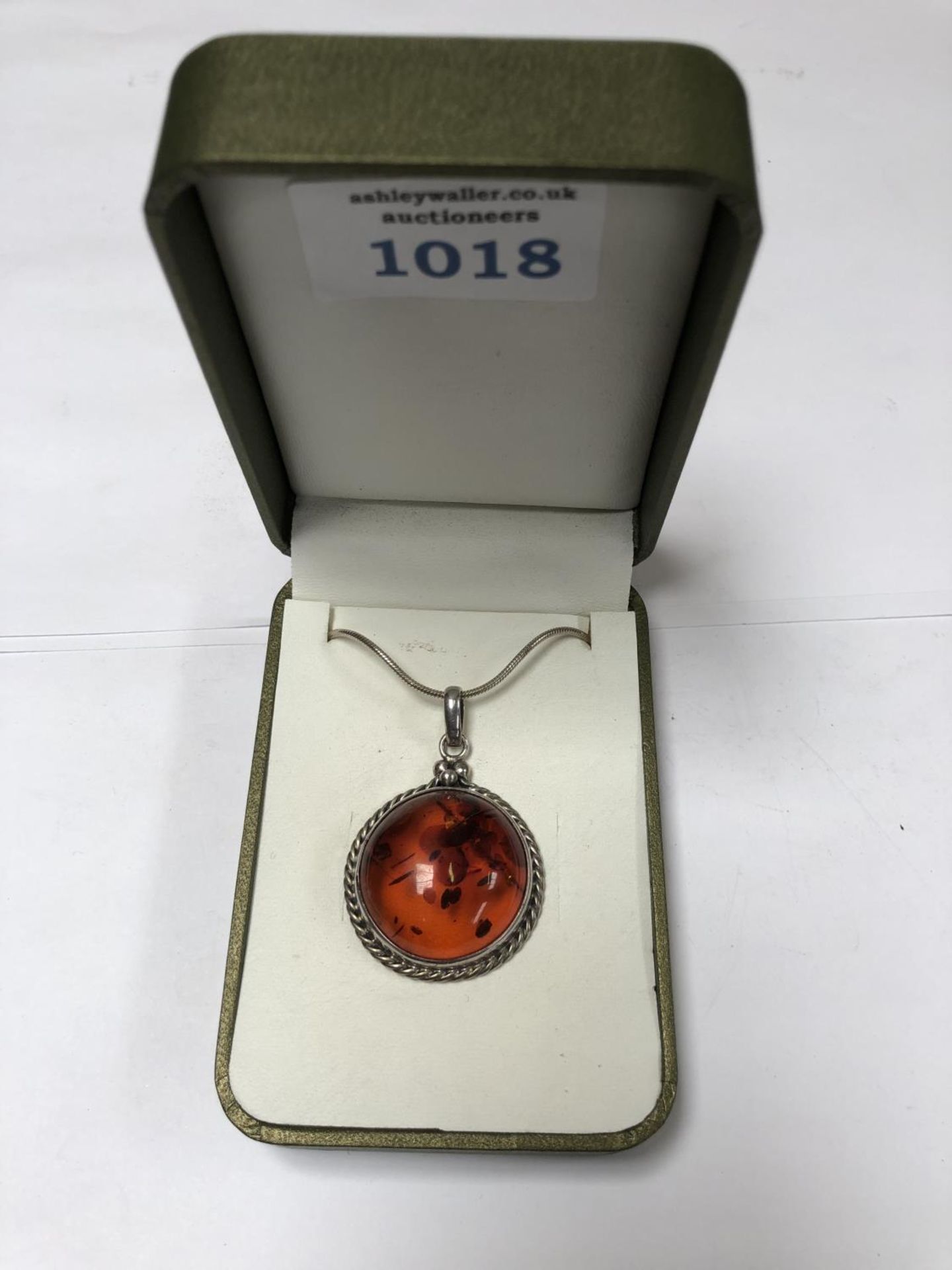 A LADIES SILVER ROUND AMBER NECKLACE
