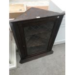 AN OAK CORNER CUPBOARD WITH LEAD GLAZED DOOR